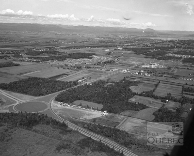 Vue aérienne de Sainte-Foy en 1952. De nombreux lots situés le long du boulevard Laurier sont alors en friche, mais plus pour longtemps. On remarque à gauche le rond-point aménagé au début des années 1950. De nos jours, on y trouve un échangeur autoroutier.